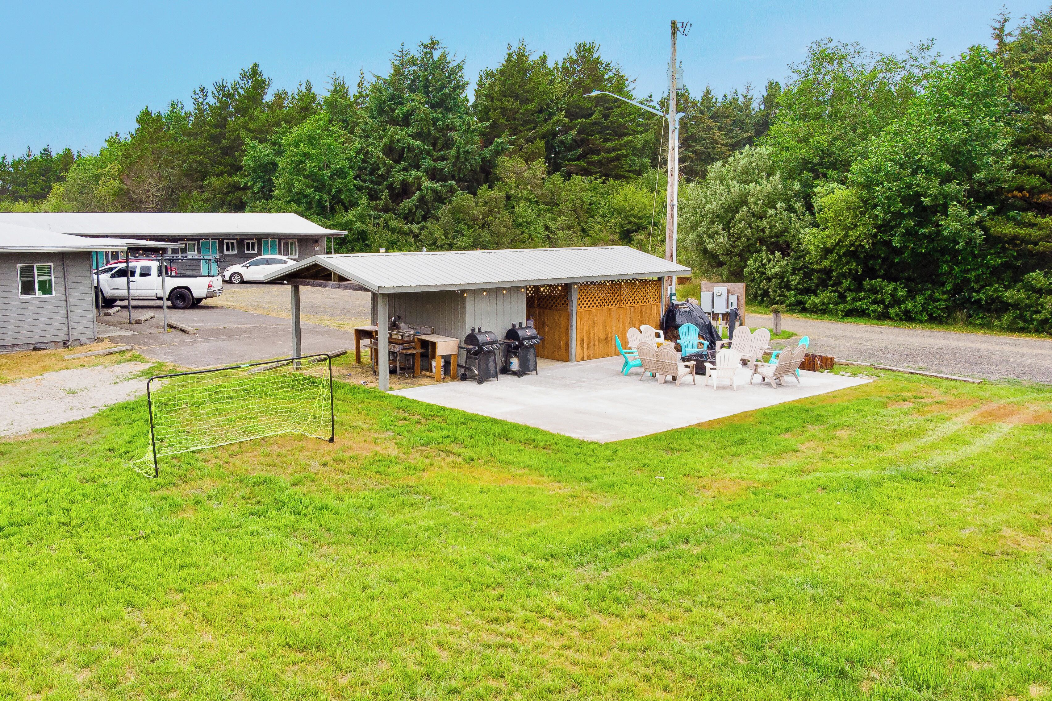 Un bâtiment doté d’un patio couvert, d’un espace extérieur aménagé pour s’asseoir et d’un barbecue.