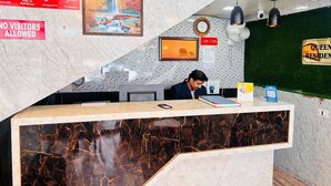 Ein Hotelrezeptionstresen mit einer Marmorplatte, einer Uhr und einem Schild mit der Aufschrift 'Besucher sind nicht erlaubt'.