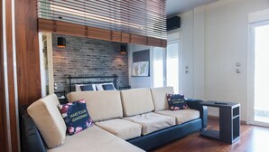Una sala de estar moderna con un sofá modular, una mesita y una pared de ladrillo.