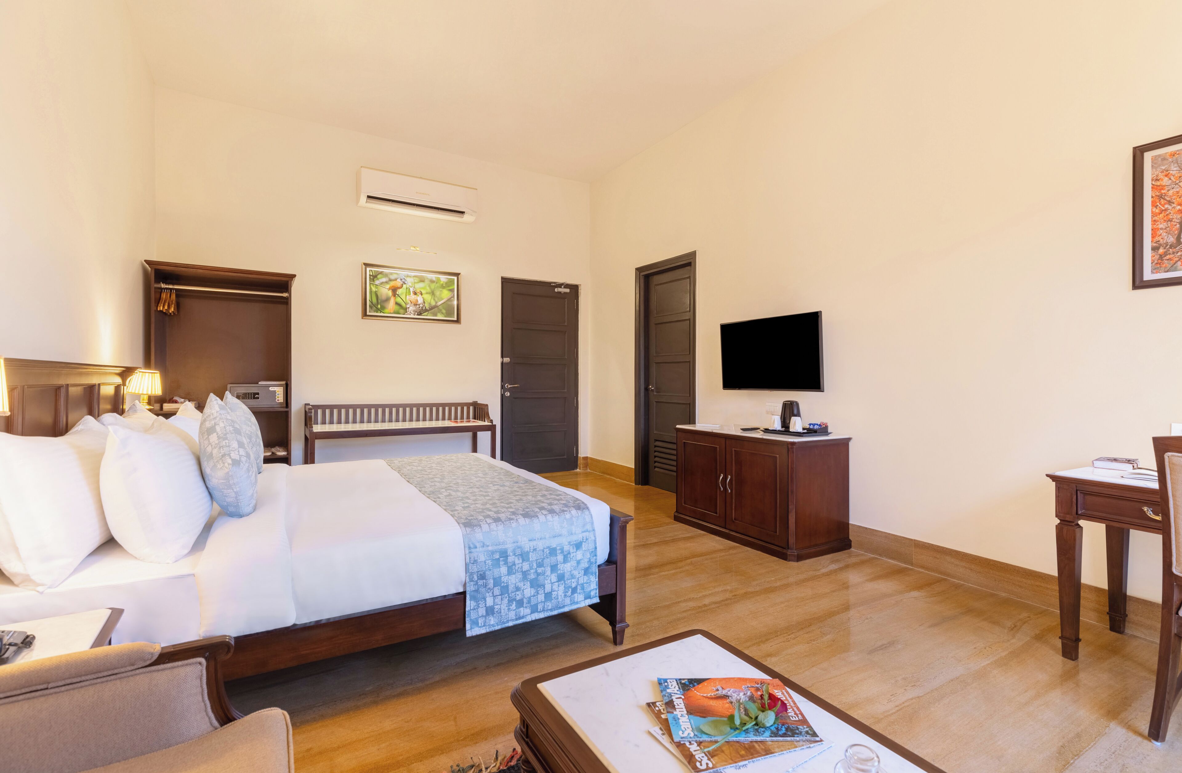 Una habitación de hotel con cama, escritorio, silla, televisor y armario.