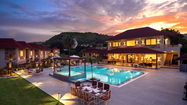 A resort with a swimming pool, outdoor seating, and a view of the surrounding landscape. - Sarasiruham Resort - Private Pool Villa in Udaipur (Udaipur)