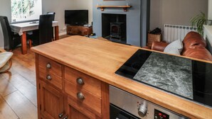Una cocina moderna con encimera de madera, horno empotrado y chimenea.