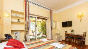 Ein Hotelzimmer mit Bett, Schreibtisch, Stuhl, Fernseher und Blick ins Freie.