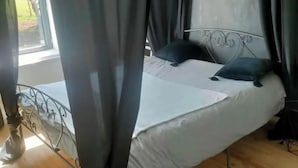Une chambre à coucher avec un lit, des rideaux et une fenêtre.
