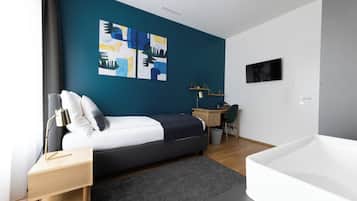 Un dormitorio moderno con cama, escritorio y una bañera grande.