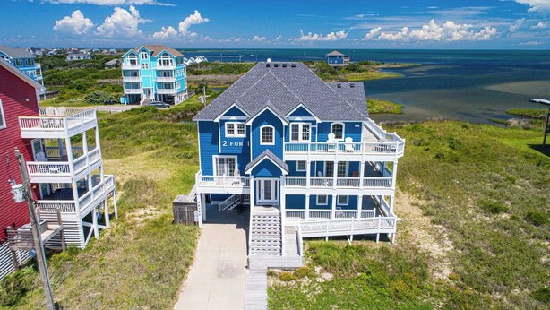 A coastal house with a two-story structure, a visible number '2', and a pathway leading to the entrance. - Premier Oceanfront Dog Friendly w/ Pool, Elevator, Hot Tub, Game and Media Rooms (Hatteras)