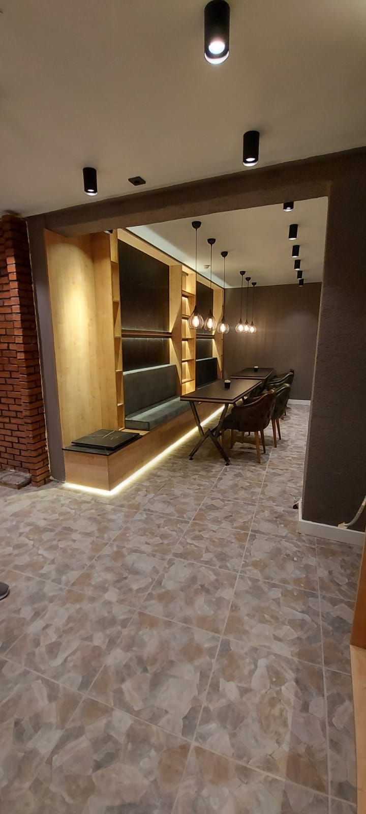 Un intérieur moderne comprenant un coin salon, une table à manger et des luminaires suspendus.