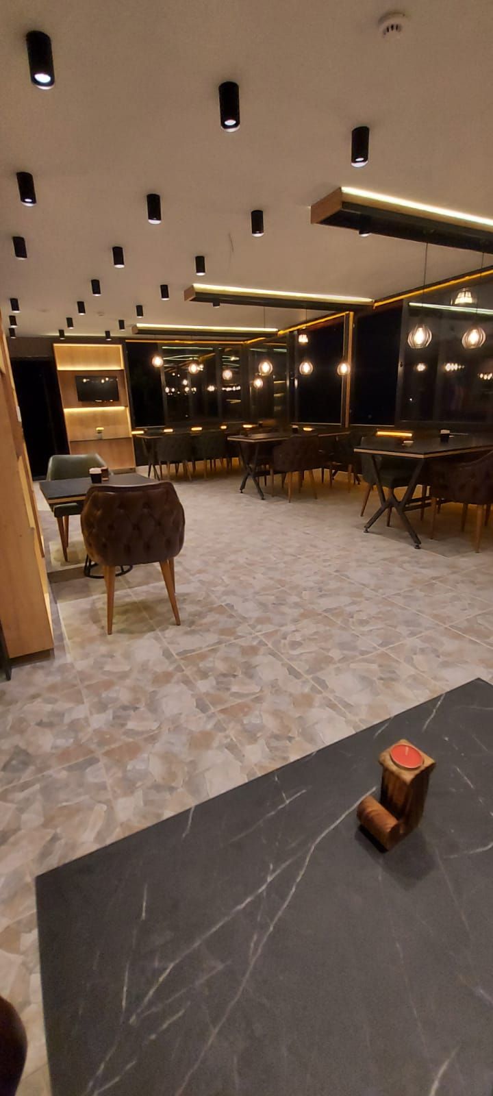A modern interior with a seating area, a reception desk, and a wall-mounted television.