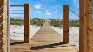 A wooden boardwalk leading to a sandy beach area with grassy dunes. - Beachfront, Pet Friendly with 2 Decks~ Windsong (Mexico Beach)