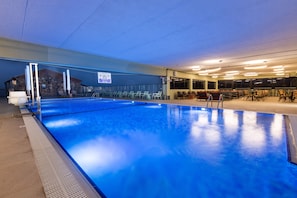 Una piscina al aire libre de temporada, sombrillas