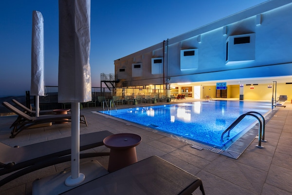 Piscina a l'aire lliure de temporada, para-sols i gandules