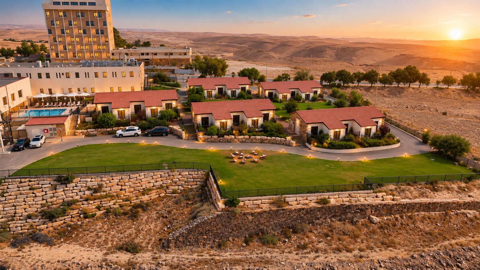 Un hotel con varias construcciones, piscina y vistas del paisaje circundante.