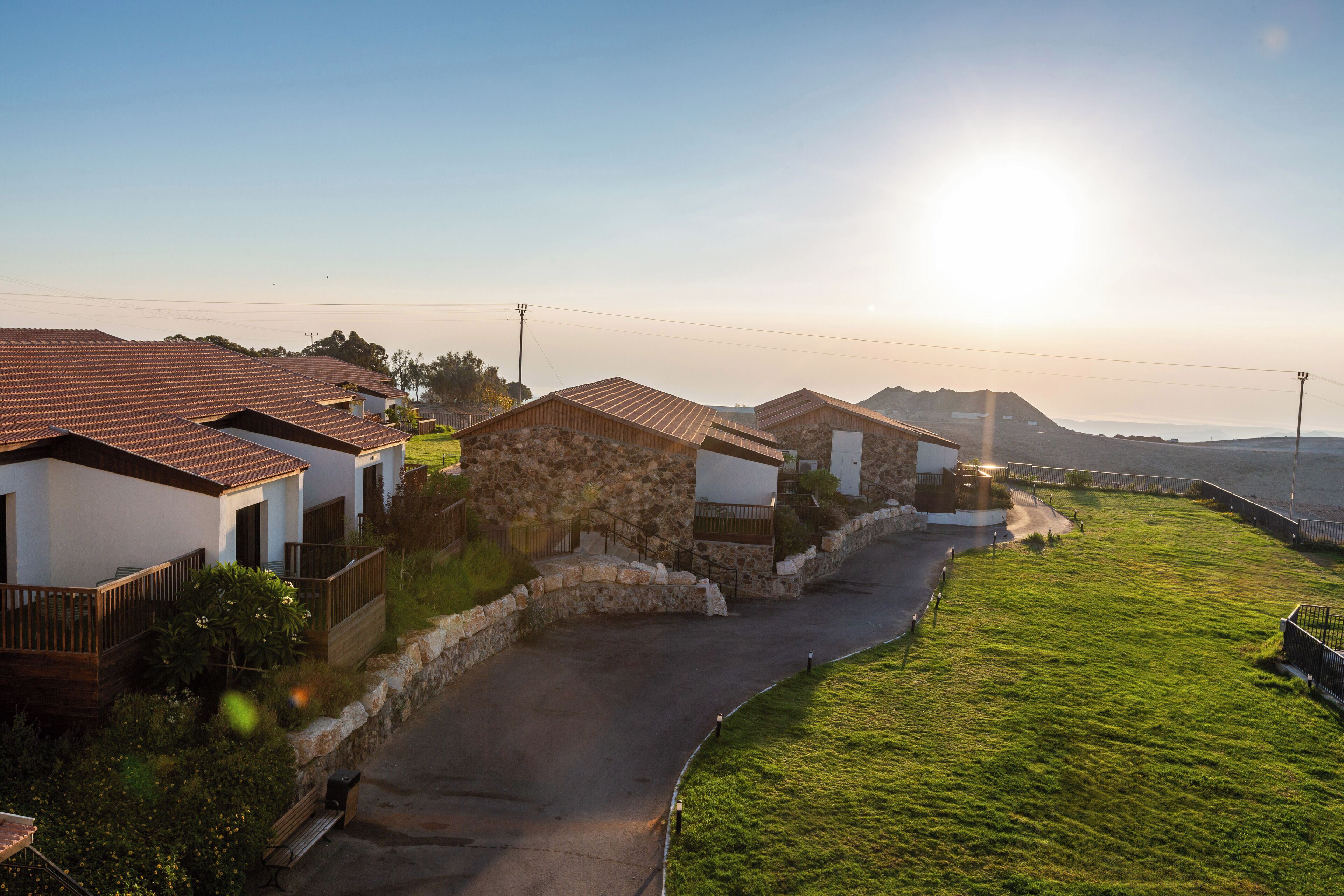 Un barrio residencial con casas, un camino pavimentado y un área con césped.