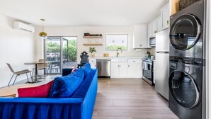 A modern kitchen with white cabinets, a built-in oven, and a large black washing machine. - Casita with Cowboy Tub & Four Peaks Wilderness (Scottsdale)