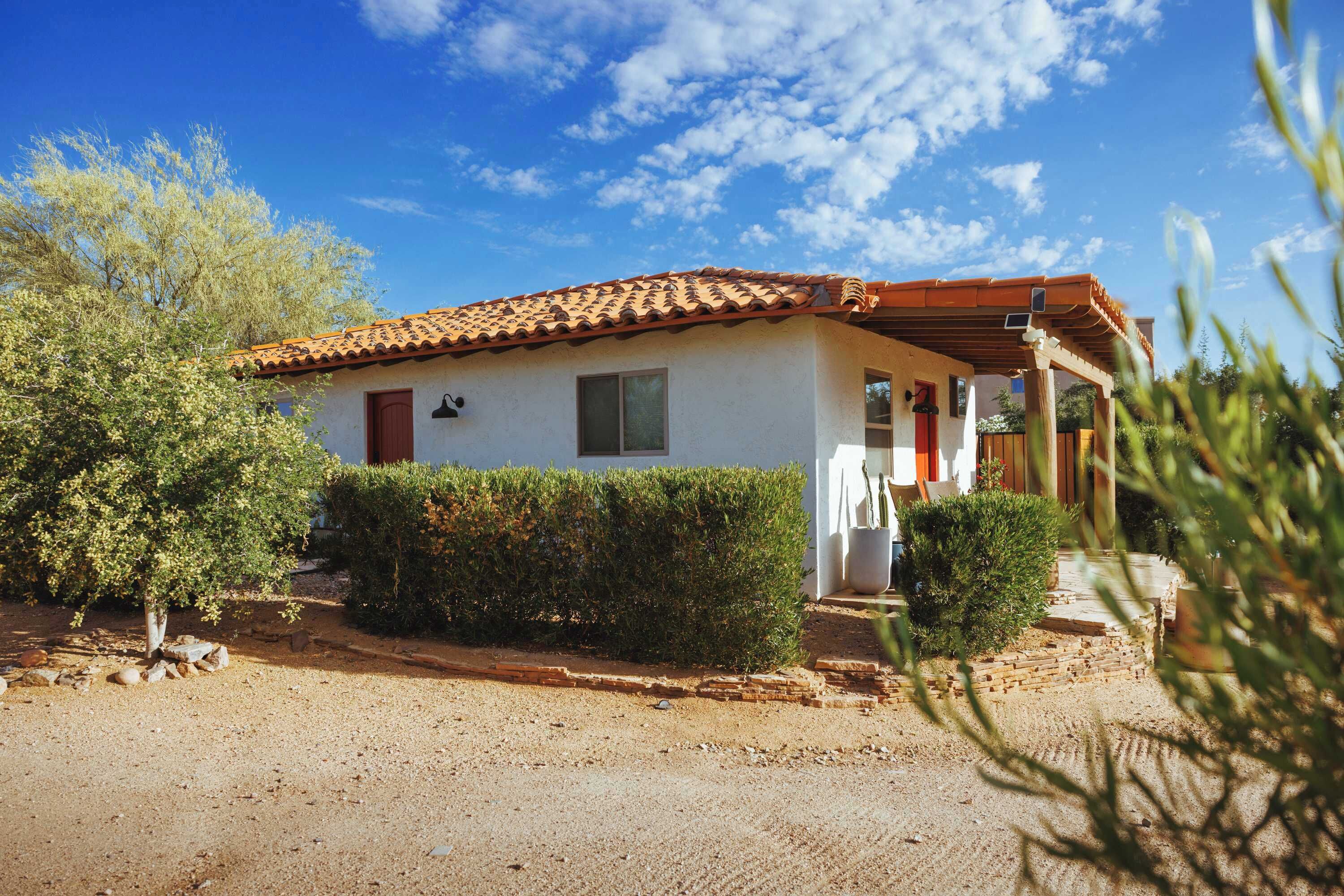 A single-story house with a tiled roof, a small porch, and a well-maintained garden.