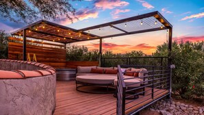 A wooden deck with a circular seating area and a pergola with string lights. - Casita with Cowboy Tub & Four Peaks Wilderness (Scottsdale)
