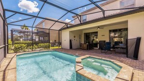 Zona de piscina exterior techada con jacuzzi, asientos en la terraza y vistas del vecindario circundante.