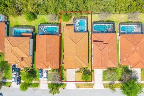An aerial view of a residential area with houses, each featuring a swimming pool and a brick roof. - Private Pool, Spa & Game Room Near Disney Parks (Kissimmee)