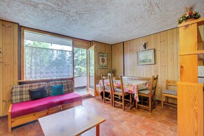 A wooden interior with a sofa, a table, and a dining area with chairs. - Appartamento Bareu Mountain View (Sauze d'Oulx)