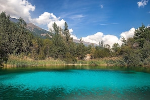 Um lago límpido rodeado por árvores e montanhas.