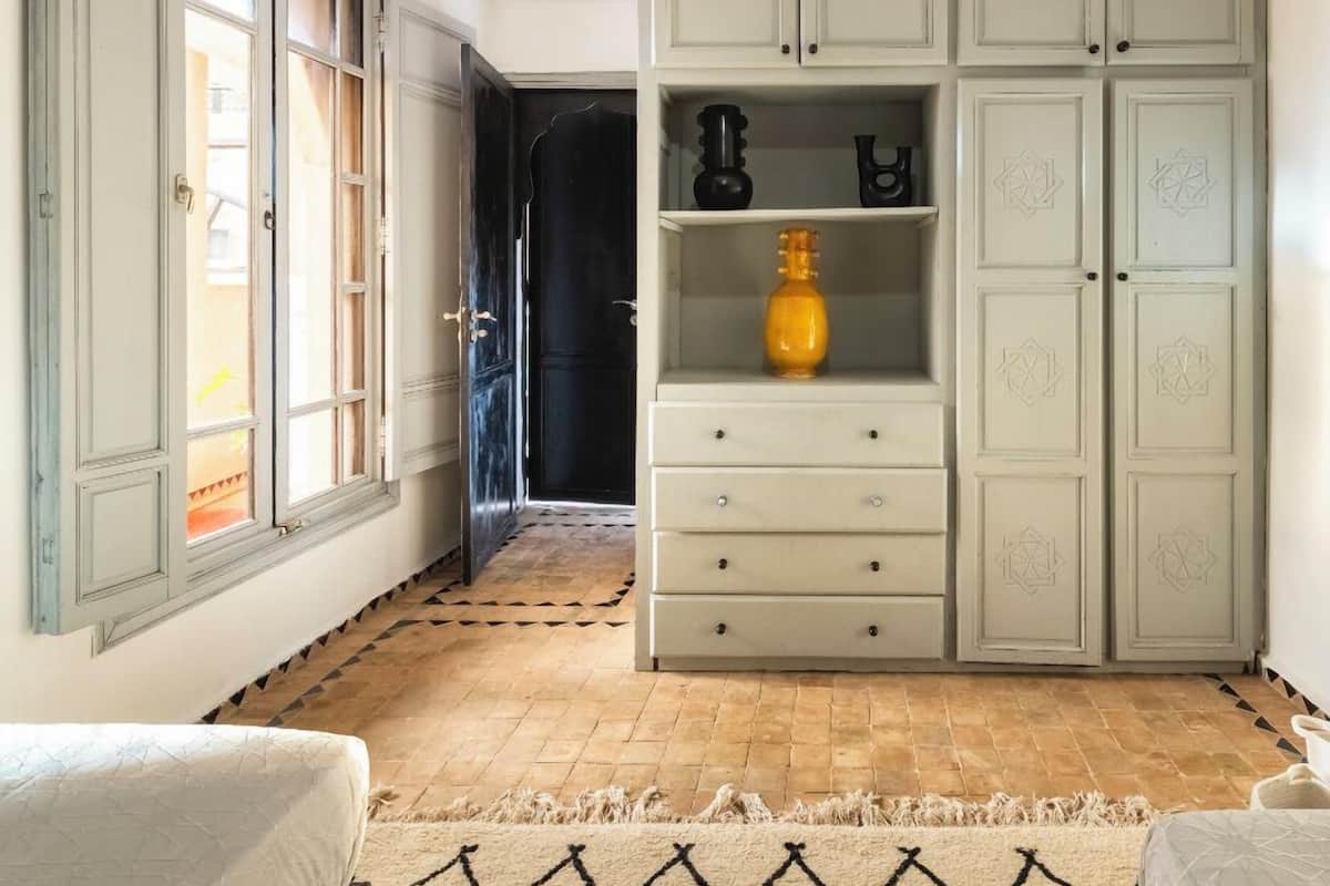 Une pièce comprenant une grande armoire, un lit et un tapis à motifs.