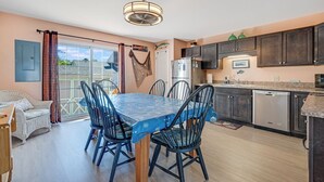 A kitchen with a dining area, a refrigerator, and a sink. - The Mermaid Lounge by Seaside Vacations & Sales (Chincoteague Island)