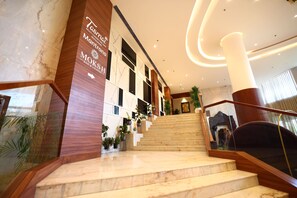 A marble staircase leading to a multi-cuisine restaurant and bar/lounge area.