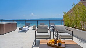 Eine Dachterrasse mit Liegestühlen, einem Whirlpool und einem Tablett mit Getränken und Snacks.