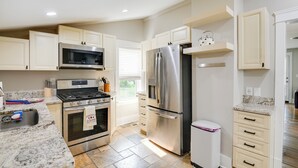 Una cocina moderna con electrodomésticos de acero inoxidable, gabinetes color beige y una encimera de granito.