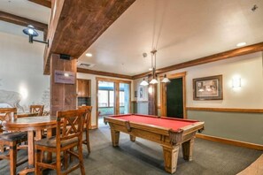 A pool table with chairs, a billiards table, and a sign indicating quiet hours. - 2 Bedroom Condo at The Springs in River Run Village (Keystone)