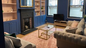 Ein Wohnzimmer mit Kamin, Fernseher und Sitzgelegenheit.