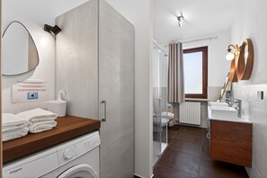 Chuveiro, secador de cabelo, toalhas de banho, papel higiênico