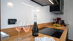 A modern kitchen with a wooden countertop, two wine glasses, and a bottle of wine. - Regarda - "Villa Ida, Giarole unit" with pool and bisg garden (Costermano)