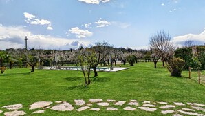 A park with green grass, stone pathways, and trees. - Regarda - "Villa Ida, Giarole unit" with pool and bisg garden (Costermano)