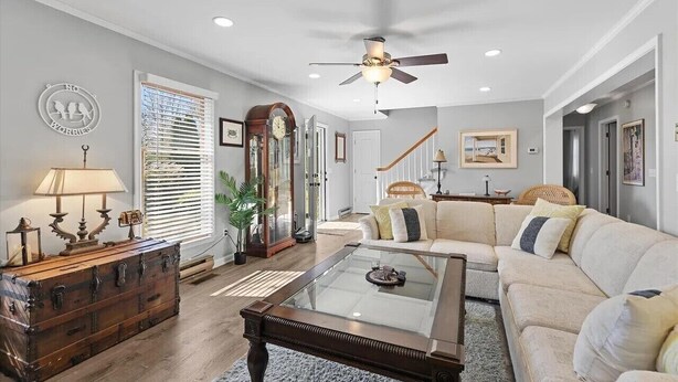A spacious living room with a glass coffee table, a beige sofa, and a wooden chest of drawers. - 4 bedroom, 2 bath home with covered deck, firepit, fenced yard - with linens! (Ocean View)