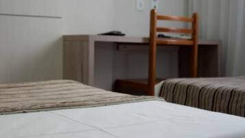 Une chambre d’hôtel avec un lit, un bureau et une chaise.
