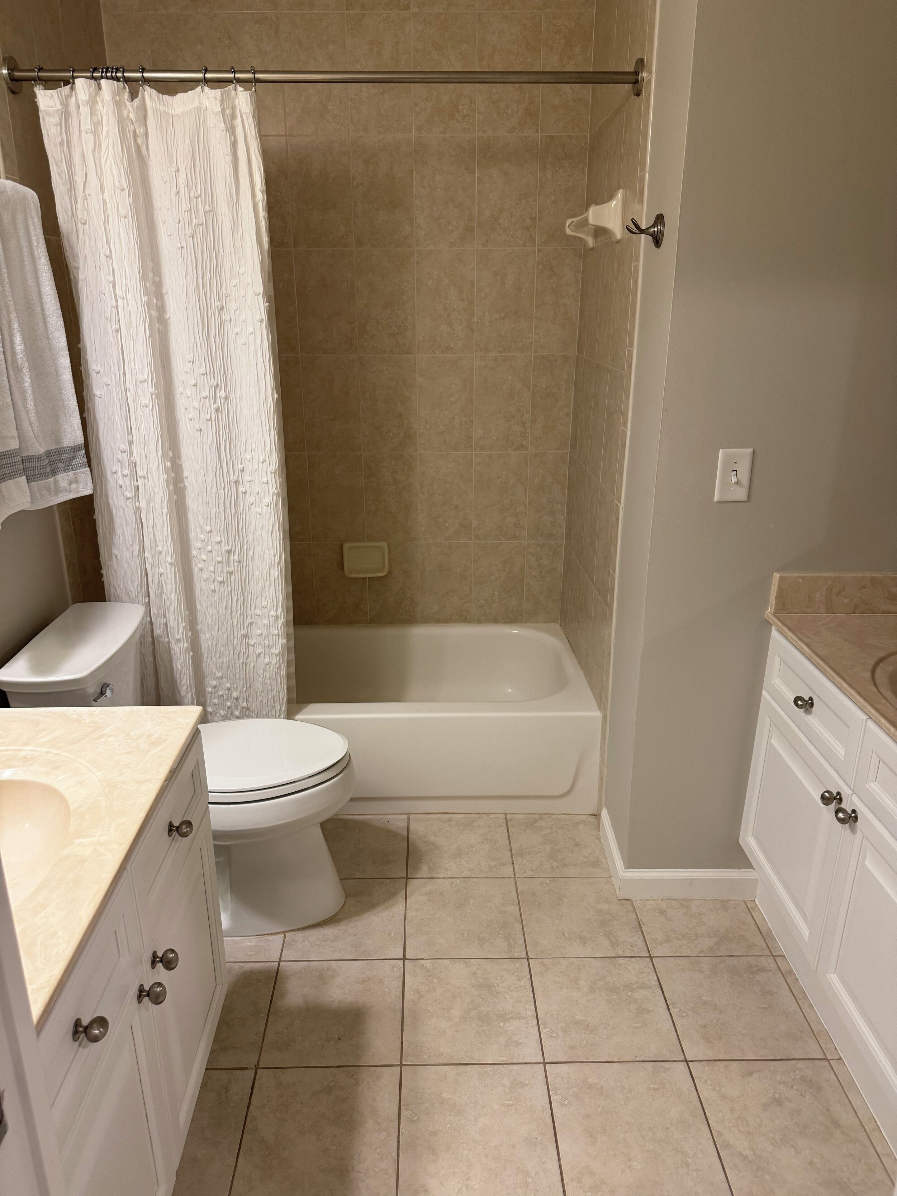 Une salle de bain équipée de toilettes, d’une baignoire et d’un rideau de douche.
