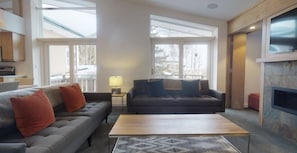 Un salon moderne avec deux canapés, une table basse et une cheminée.