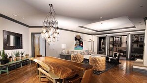 A spacious dining area with a wooden table and chairs, a chandelier, and a large mirror on the wall. - Arrabelle at Vail Luxe 3 Bedroom Residence With Ski-in, Ski-out Access (Vail)