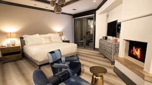 A modern bedroom with a large bed, a fireplace, a TV, and a seating area. - Arrabelle at Vail Luxe 3 Bedroom Residence With Ski-in, Ski-out Access (Vail)
