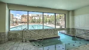 A large indoor swimming pool with a view of a resort complex. - Water House Luxury 2 Bedroom on Main Street - Walk to Quicksilver Lift! (Breckenridge)