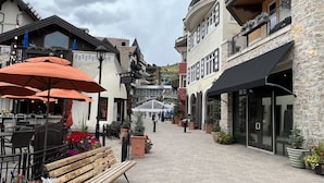 Una calle empedrada con mesas al aire libre y arreglos florales.