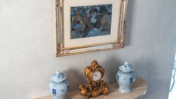 A wall-mounted picture frame with a clock and two vases on a wooden shelf.