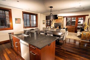 Una cocina moderna con una isla central, comedor y chimenea.