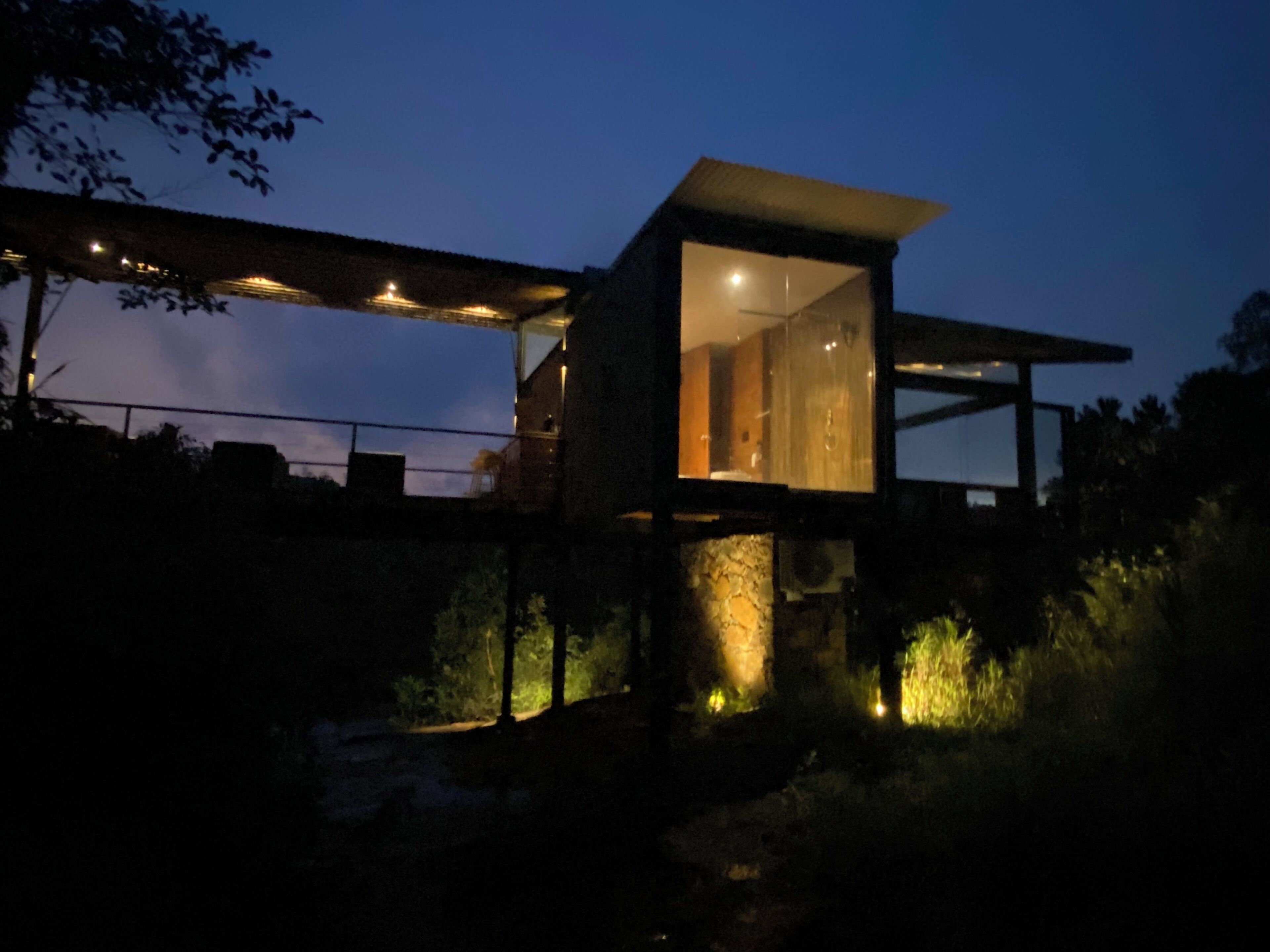 A modern house with a glass facade, a large open space, and a balcony.