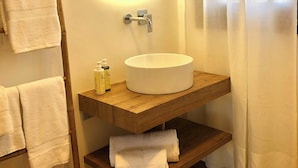 A bathroom with a wooden vanity, a round mirror, and a white sink. - Il Borgo Boutique rooms By Kasa Vacanze  (Loiri Porto San Paolo)