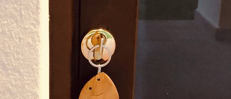 A door with a golden handle and a keychain shaped like a fish with the text "KASAVACANZE".