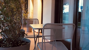 A modern patio area with a metal chair and a potted plant. - Il Borgo Boutique rooms By Kasa Vacanze  (Loiri Porto San Paolo)