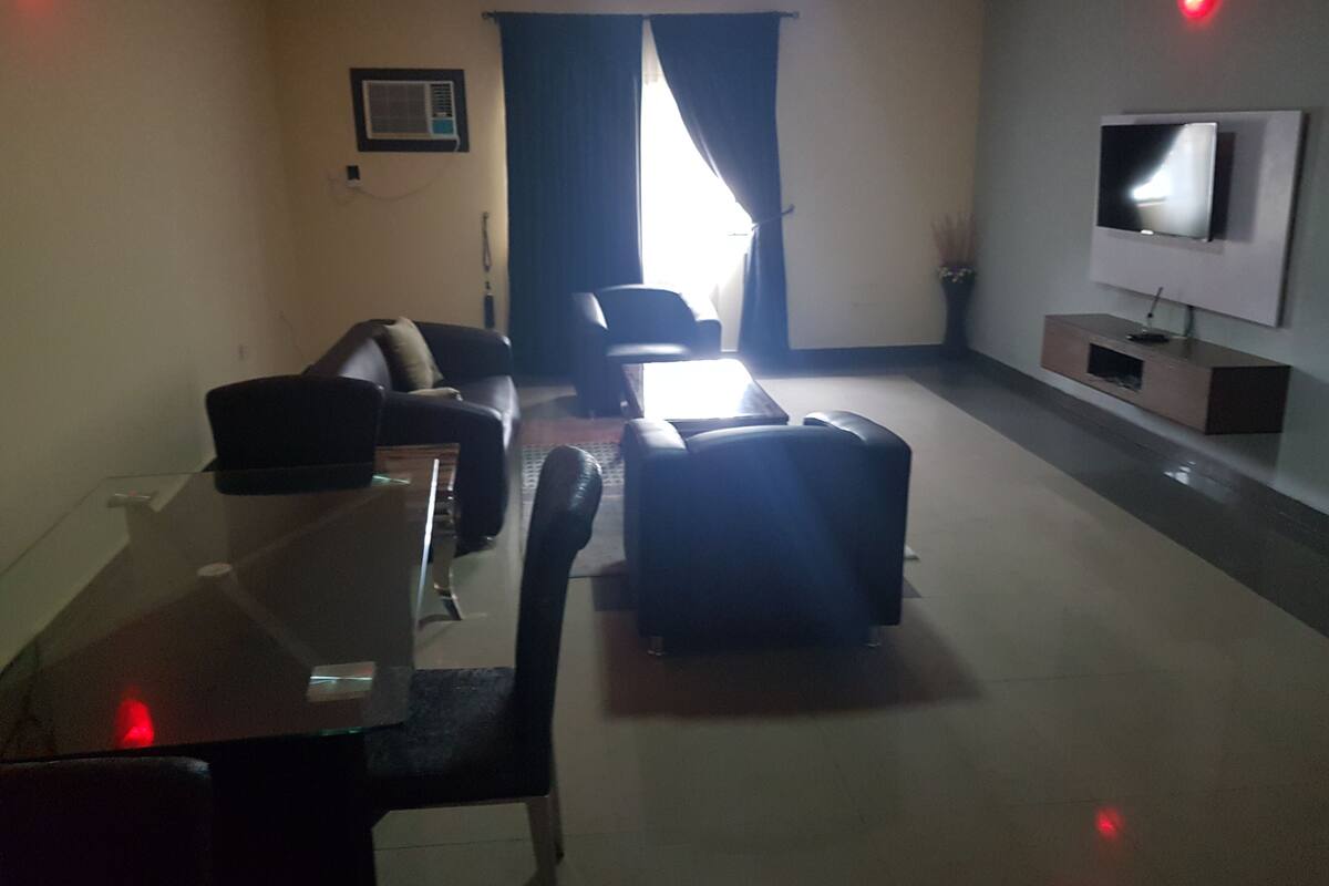 A living room with a sofa, a coffee table, and a TV on a stand.