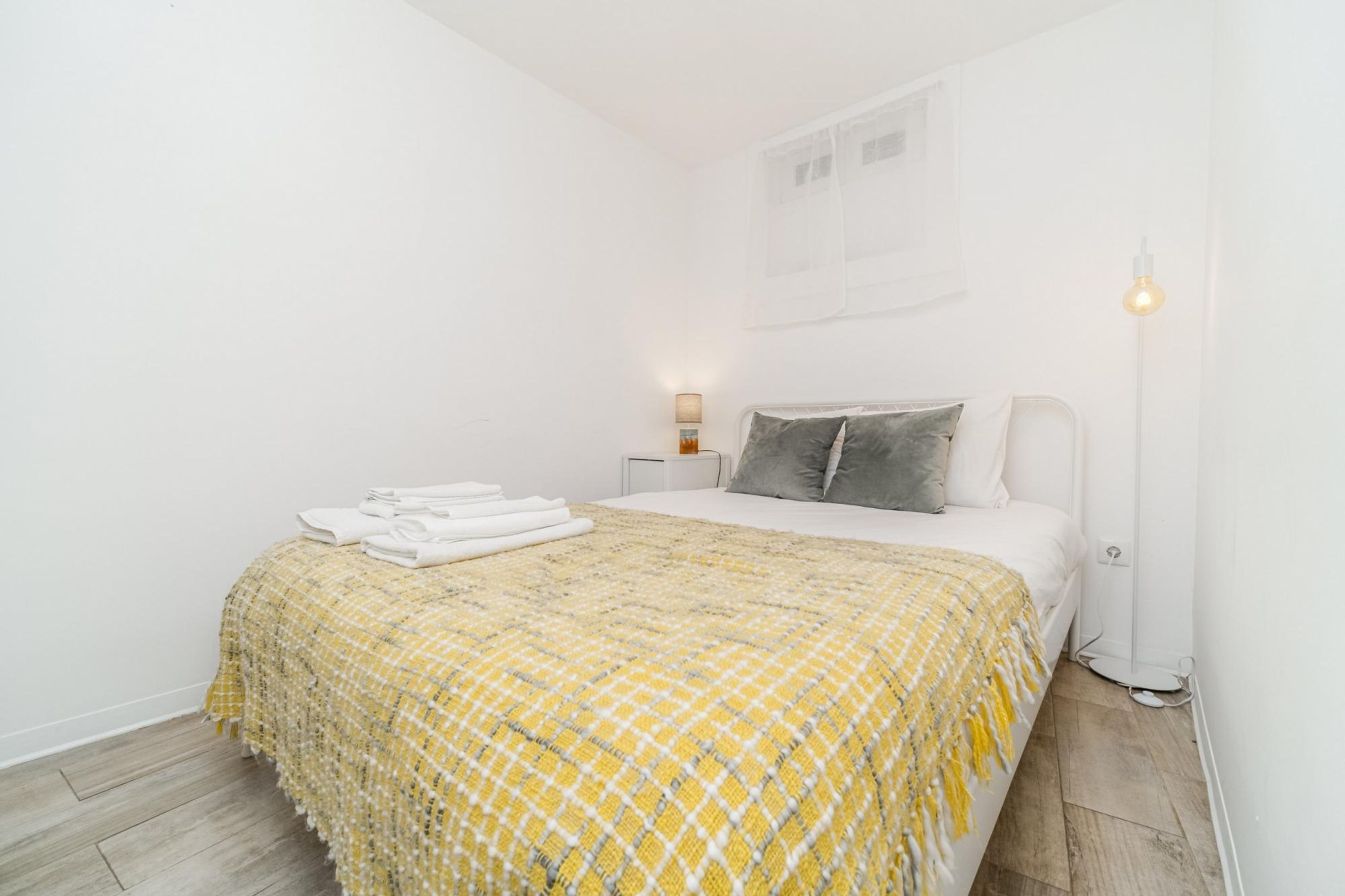 A bedroom with a bed, a bedside lamp, and a floor lamp.